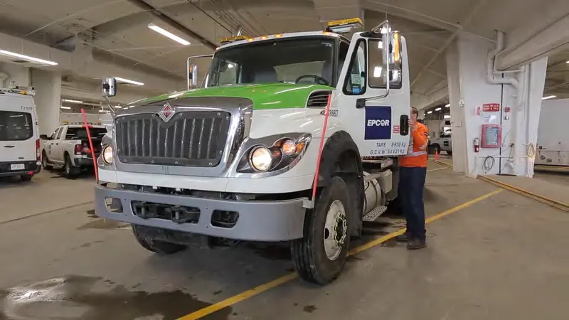 An EPCOR field technician beside a service truck